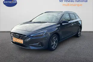 Hyundai i30 SW 2024 gris Dark Knight Metal vue 3/4 avant droit avec calandre distinctive et jantes alliage.