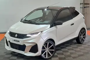 Vue 3/4 avant d'une Aixam Ambition 0.5 City Coupe GTI blanche avec toit noir et jantes alliage noires.
