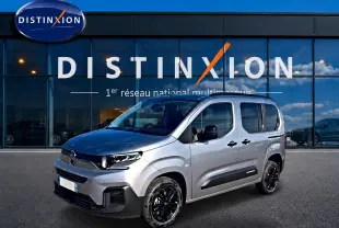 Citroën Berlingo Steel Grey vue 3/4 avant droit, avec jantes noires et barres de toit visibles.