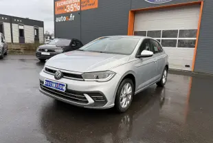 Volkswagen Polo 1.0 TSI Style argent métallisé vue 3/4 avant sur parking devant un garage autos.fr