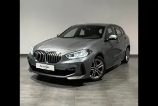 BMW Série 1 118dA M Sport gris Skyscraper vue 3/4 avant avec phares LED allumés sur sol intérieur.