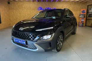 Vue 3/4 avant d'un Hyundai Kona noir 2023 avec calandre noire et phares LED allumés en intérieur showroom.