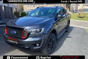 Ford Ranger gris foncé en 3/4 avant droit, avec calandre noire et accents rouges distinctifs.
