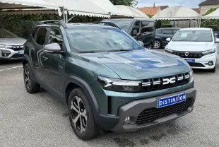 SUV Dacia Duster Hybrid 140 Journey vert cèdre en 3/4 avant avec calandre noire distinctive et jantes noires et argentées.