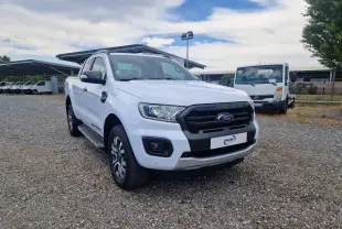 Ford Ranger Super Cabine blanc vu en 3/4 avant droit, avec calandre noire et marchepieds visibles.