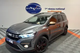 Dacia Jogger gris schiste métal en 3/4 avant droit, avec jantes noires et rétroviseurs couleur or mat.