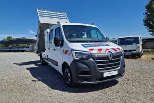Renault Master blanc vue 3/4 avant droit avec benne relevée et marquages rouges sur capot et portières.