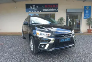 Mitsubishi ASX noir en 3/4 avant droit, avec calandre chromée et jantes 16 pouces visible sur parking gravillonné.