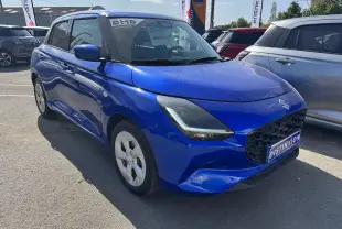 Vue 3/4 avant droit d'une Suzuki Swift 1.2 Privilège Hybrid bleue, avec calandre noire et jantes argentées.