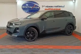 Vue 3/4 avant droit d'un Citroën C5 hybride vert avec jantes noires et calandre moderne dans un showroom.