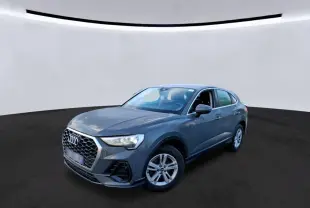 Audi Q3 Sportback gris en vue 3/4 avant droit, avec calandre hexagonale et jantes 17 pouces cinq branches doubles.