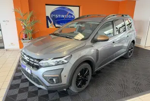 Vue 3/4 avant d'un Dacia Jogger gris schiste métallisé avec jantes noires et rétroviseurs bronze en showroom.