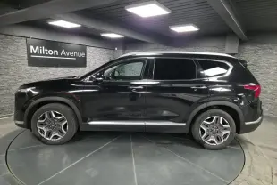 Vue latérale gauche du Hyundai Santa Fé noir 2023 avec jantes alliage et vitres teintées en showroom.