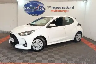Toyota Yaris hybride blanche vue de profil avant droit dans un showroom avec logo Distinxion en arrière-plan.