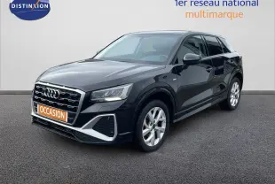 Audi Q2 noir mito métal en 3/4 avant droit, avec calandre S-Line et jantes argentées visibles sur sol gris.