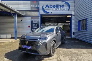 Peugeot 3008 gris titane en 3/4 avant droit devant un garage avec logo Abeilhé autos visible.