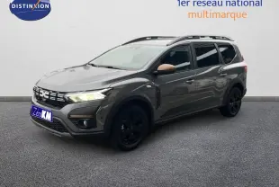 Dacia Jogger gris schiste métal en 3/4 avant droit avec jantes noires et rétroviseurs couleur cuivre.