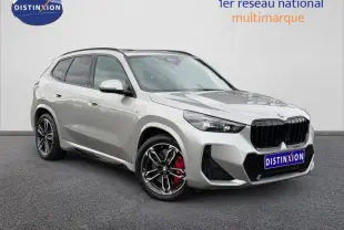 BMW X1 xDrive20d M Sport gris Spacesilber métal vue 3/4 avant avec jantes alu et étriers de frein rouges.