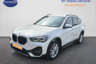 BMW X1 blanc vue 3/4 avant droit, avec calandre noire et jantes alliage 17 pouces visibles.