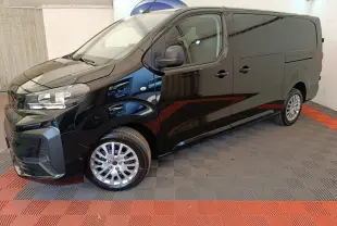 Vue 3/4 avant droit du Peugeot Expert Fourgon XL noir, avec jantes alliage et rétroviseurs noirs, dans un showroom.