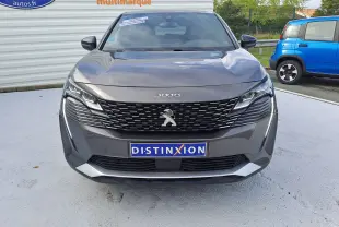 Vue frontale d'un Peugeot 3008 gris platinium 2024 avec calandre noire et logo lion chromé visible.
