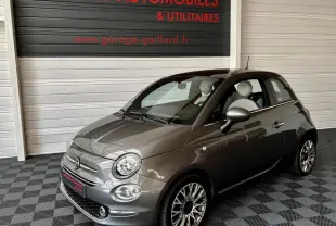 Fiat 500 gris foncé vue 3/4 avant droit, jantes alliage et intérieur clair visibles en showroom.