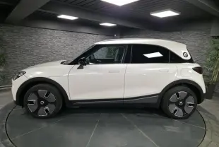 Vue de profil côté gauche d'une Smart #1 électrique blanche avec toit blanc et jantes noires stylisées.