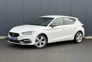 Vue 3/4 avant droite d'une SEAT Leon 1.5 e-TSI 150 DSG7 FR blanche avec jantes alliage 17 pouces et vitres surteintées.