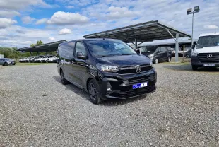 Vue 3/4 avant d'un Citroën Jumpy XL noir avec jantes tôles 17, stationné sur un sol gravillonné en extérieur.