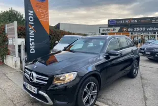 Mercedes GLC 250 D 4MATIC noir vue 3/4 avant droit sur parking devant panneau Distinxion.