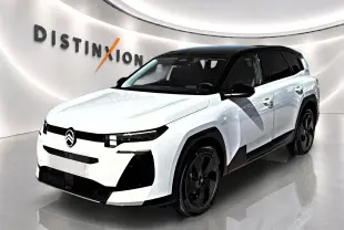 Vue 3/4 avant droit du Citroën C5 Aircross blanc à toit noir avec jantes alliage noires dans un showroom.