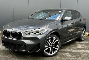 BMW X2 gris minéral en vue 3/4 avant droit avec jantes alliage bicolores et calandre M Sport distinctive.
