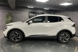 KIA SPORTAGE blanc nacré vu de profil côté gauche, avec jantes alliage noires et vitres surteintées.