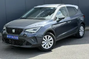 SEAT Arona TSI 115 Style 2025 en gris magnétique avec toit blanc, vue 3/4 avant droit sur fond urbain.