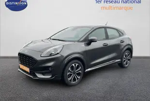 Ford Puma 2024 gris magnétique en 3/4 avant droit, avec jantes alliage et calandre noire distinctive.