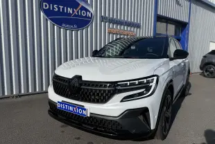 Renault Austral Hybrid blanc nacré avec toit noir, vue 3/4 avant droit, calandre noire et phares LED distinctifs.
