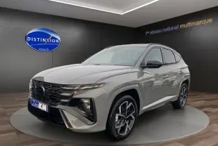 Vue 3/4 avant d'un Hyundai Tucson gris foncé avec jantes alliage et calandre imposante en showroom.