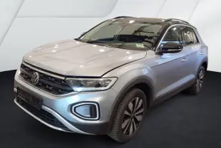Volkswagen T-Roc gris clair en 3/4 avant droit, avec toit noir et feux LED allumés.