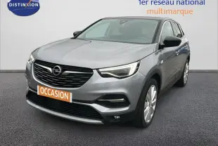 Opel Grandland X gris clair vu en 3/4 avant droit avec jantes alliage 19 pouces et phares LED allumés.