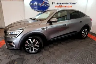 Renault Arkana Business E-TECH 145 gris foncé vu de profil côté gauche dans un showroom avec logo Distinxion en arrière-plan