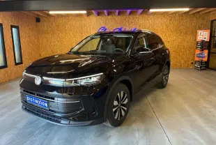 Volkswagen Tiguan 1.5 TSI noir grenadilla métal en 3/4 avant droit dans un showroom intérieur.