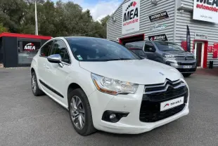 DS4 blanc nacré en 3/4 avant droit, avec calandre noire et jantes alliage 17 pouces visibles devant un garage MEA automobile.
