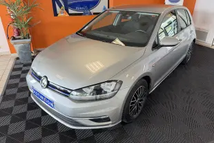 Volkswagen Golf TSI 130 Confortline gris vue 3/4 avant droit en intérieur avec jantes noires multibranches.