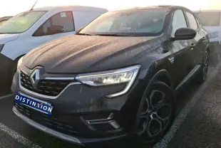 Vue 3/4 avant droit d’un Renault Arkana noir métal 2023 avec jantes bi-ton et calandre chromée, en intérieur showroom.