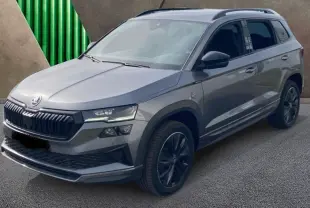 SKODA KAROQ gris graphite vu en 3/4 avant droit avec jantes noires et calandre marquée Sportline.