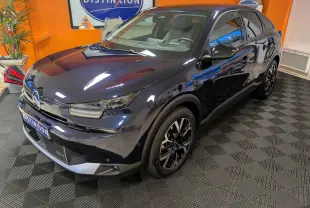 Citroën C4 hybride bleu nuit vue 3/4 avant droit, jantes alliage 18 pouces et intérieur clair visible.