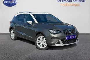 Vue 3/4 avant d’un SEAT Arona noir avec jantes alu blanches et calandre distinctive, sur fond neutre.