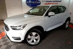 Vue 3/4 avant d'un Volvo XC40 gris clair garé en intérieur avec jantes alliage et calandre noire distinctive.