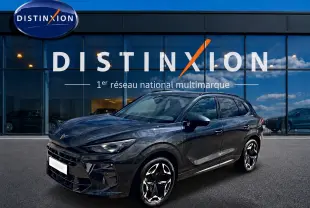 Vue 3/4 avant d'un CUPRA Terramar gris Timanfaya avec jantes alu noires et détails sportifs, devant une vitrine Distinxion.