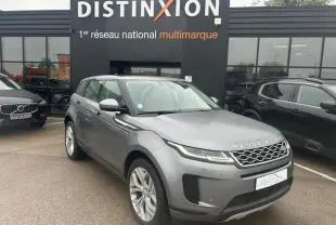 Range Rover Evoque gris foncé métallisé vu en 3/4 avant droit devant un showroom Distinxion.